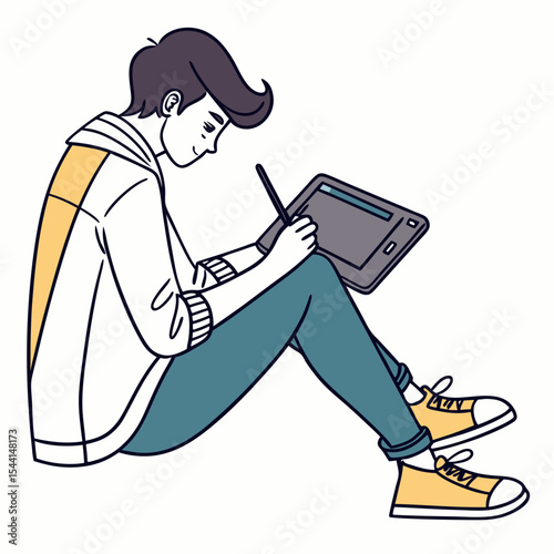 Young man drawing on graphics tablet sitting floor