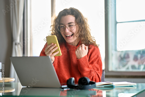 Cuadro en lienzo Happy young woman student feeling excited winner holding cellphone using mobile phone winning online, receiving great news or sms offer looking at smartphone, getting new job celebrating success