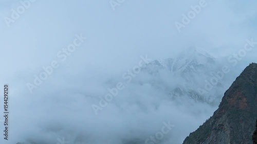 4K Time Lapse of dark monsoon clouds rolling in snowy Himalaya mountains at Miyar Valley, Lahaul, India. Snow storm, bad weather, stormy clouds in mountains. Snow storm during winter in Himalayas