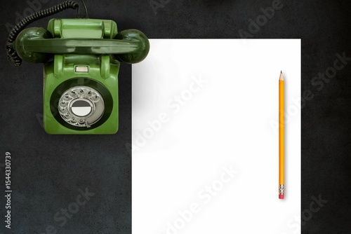 Pen on a piece of paper in front of old phone