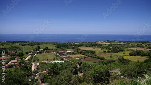 Cultivated fields and houses dot the landscape near Tropea, with the Tyrrhenian Sea stretching to the horizon