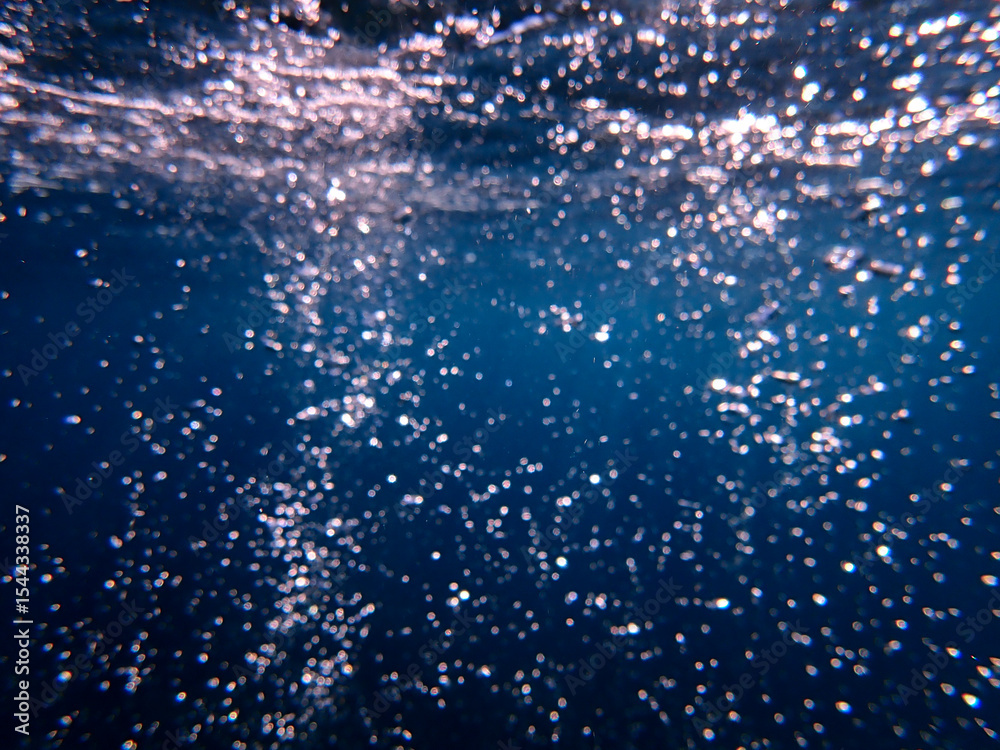 Fototapeta premium Ocean blue underwater with sunrays, Underwater Sea Deep Water Abstract Sunshine, sea wave , clean waters in summer time, Natural underwater seascape, sand on ocean floor and water surface with sunligh