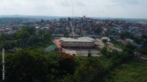Mokola Hill view from hotel construction site with city of Ibadan in background. Beautiful hilltop houses sited along busy express road as drone pans through greeny lush