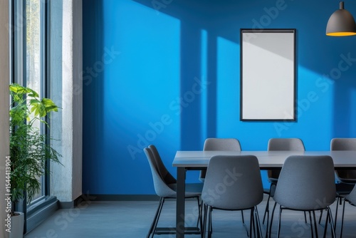 A blue room with a white framed picture on the wall. Blue and gray office meeting room with poster.