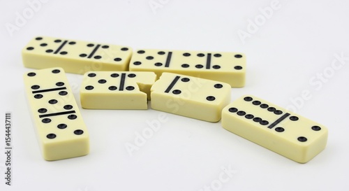 Scattered dominoes playfully rest on bright white background. AI Generated