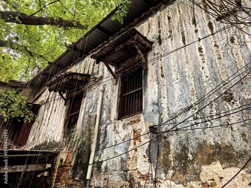 Old weathered building facade with exposed bricks and wires