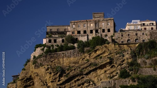 Old town of Pizzo Calabro rising on a tufa cliff under blue sky in Calabria, Italy