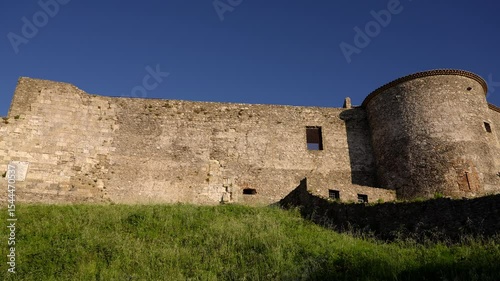 The imposing Norman Castle of Vibo Valentia stands on a green hill, showcasing its historical architecture against a clear blue sky in Calabria, Italy