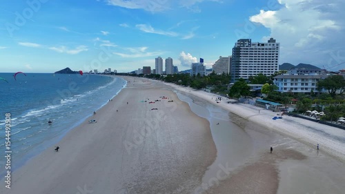 Drone footage of long city beach and calm ocean waves