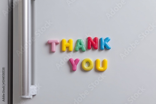 Colorful magnetic letters spell gratitude on a fridge door, evoking Friendship Day vibes and unexpected alphabet symphonies