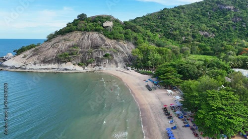 Clean beach at base of jungle-covered hillside in Asia