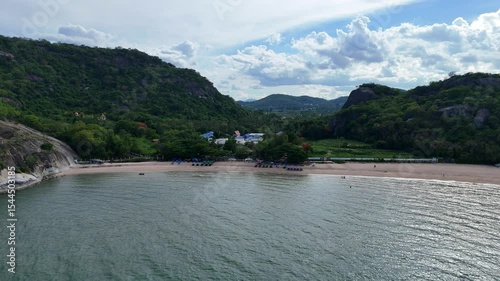 Remote Thai beach between forested hills aerial view
