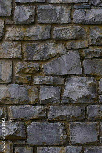 Medieval wall built with dark stone masonry