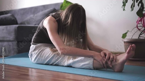 Young woman practicing yoga at home on mat