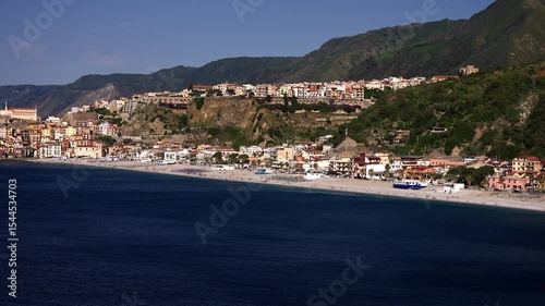 Panoramic view of the beautiful Scilla, Calabria, Italy, featuring its beach, colorful houses, and Aspromonte mountains in the background