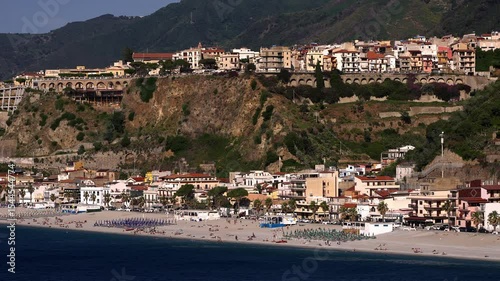 Panoramic view of Scilla, Calabria, with colorful buildings on a cliff overlooking the beach and the Tyrrhenian Sea, a popular tourist destination in Italy