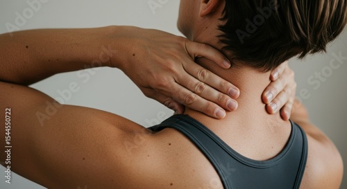 Person massages tense neck muscles with hands