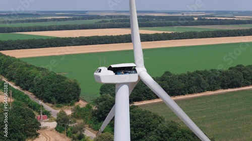 Wind turbine technician at work during maintenance on top of nacelle