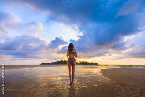 Happy traveler asian woman with bikini relax on sea Klong Rahan beach in sunset at Koh Kood Trat Thailand Summer travel holiday vacation concept