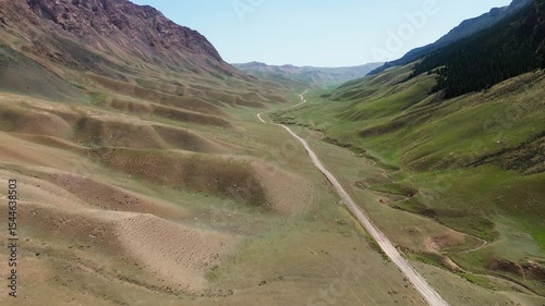 Aerial view of Kyrgyzstan lonely road into the mountain pass green Vally 