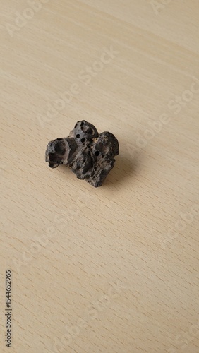 pierre étrange similaire à une météorite sur table en bois