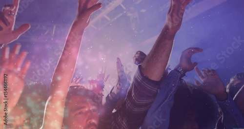 Beat drop sending music crowd raising hands and cheering under purple lights with confetti swirling