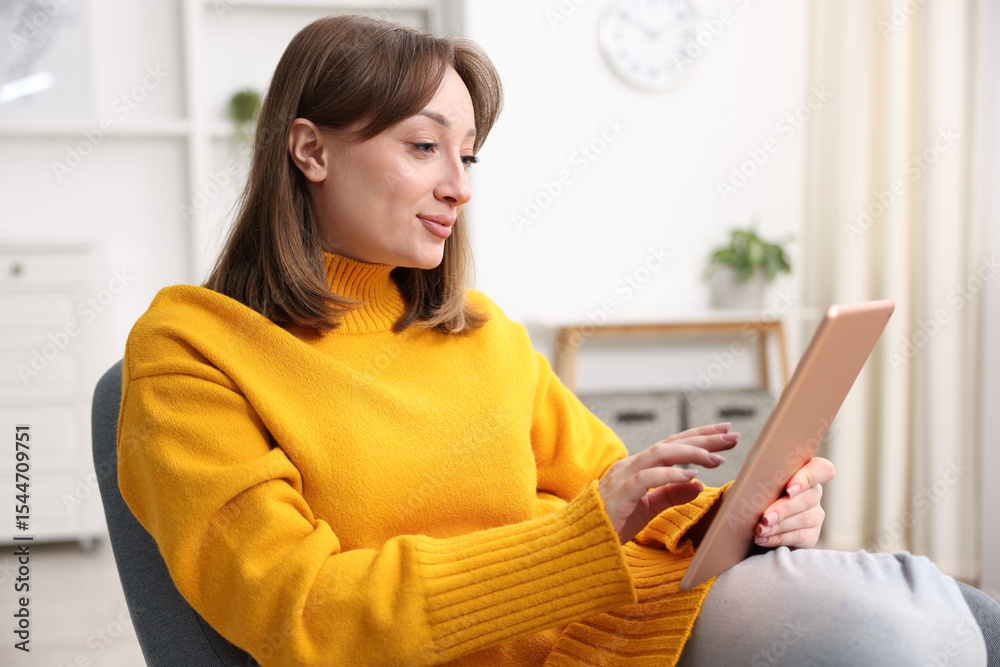 Woman with modern tablet in armchair at home Woman with modern tablet in armchair at home