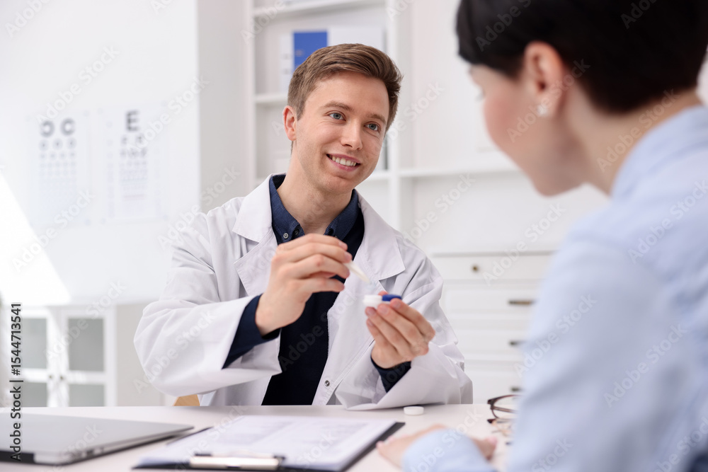Obraz premium Ophthalmologist teaching patient to use contact lenses at table in office