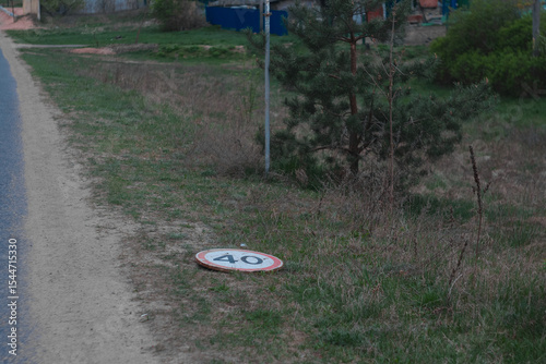 dirt road with 40 kmh speed limit and warning sign lies on the ground