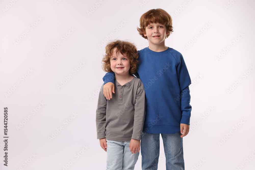 Cute little brothers posing on white background. Space for text Cute little brothers posing on white background. Space for text
