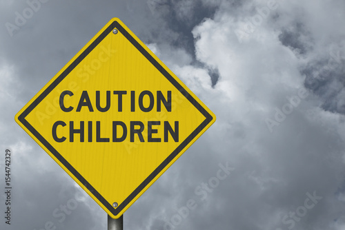 Caution Children yellow warning sign with stormy cloudy sky