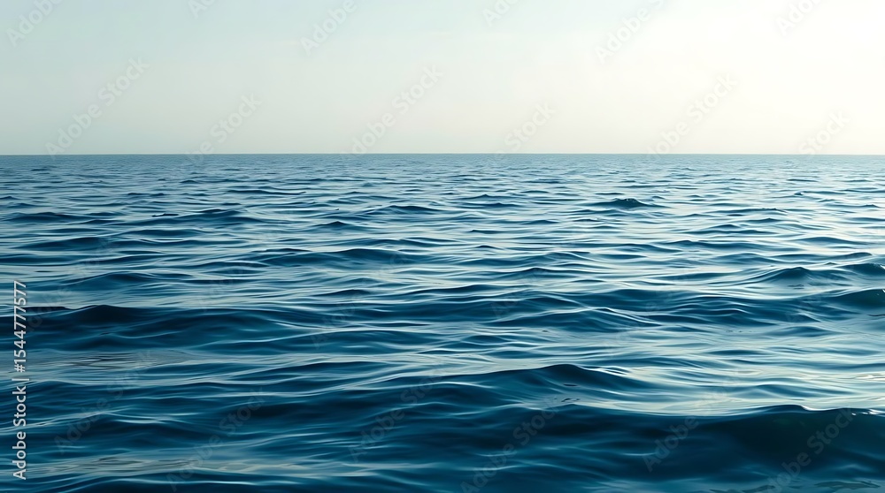 Fototapeta premium A tranquil blue ocean stretches to the horizon under a clear sky, its gentle waves creating a peaceful seascape
