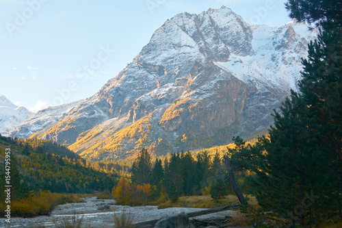 Stunning autumn scenery of famous alp peak Matterhorn capped by snow and yellowed larches on foreground. Swiss Alps, Valais, Switzerland