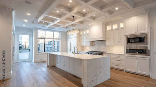 The spacious and bright modern kitchen features an island with marble countertop, white cabinets, and beautiful coffered ceiling with recessed lighting design.
