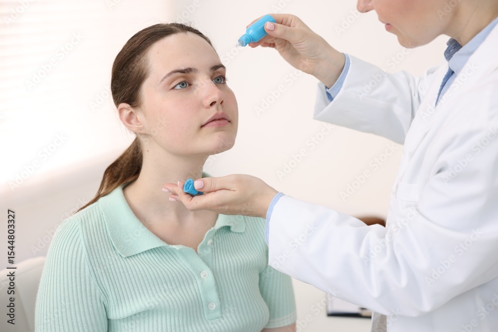 Ophthalmologist applying medical drops onto patient's eye in clinic, closeup Ophthalmologist applying medical drops onto patient's eye in clinic, closeup