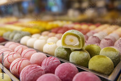 A display of colorful mochi balls arranged in rows, each with different colors