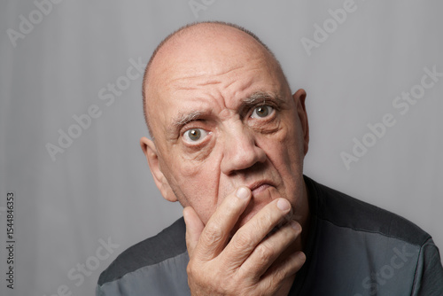 portrait vieil homme au regard expressif sur fond gris