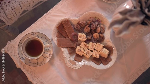 Traditional Mediterranean sweets and herbal tea served on vintage embroidered tablecloth with lace details
