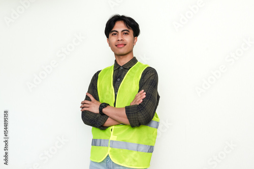 Confident Asian construction worker crossing arms and smiling at the camera on white background. Perfect for industrial, labor, or recruitment advertisement themes