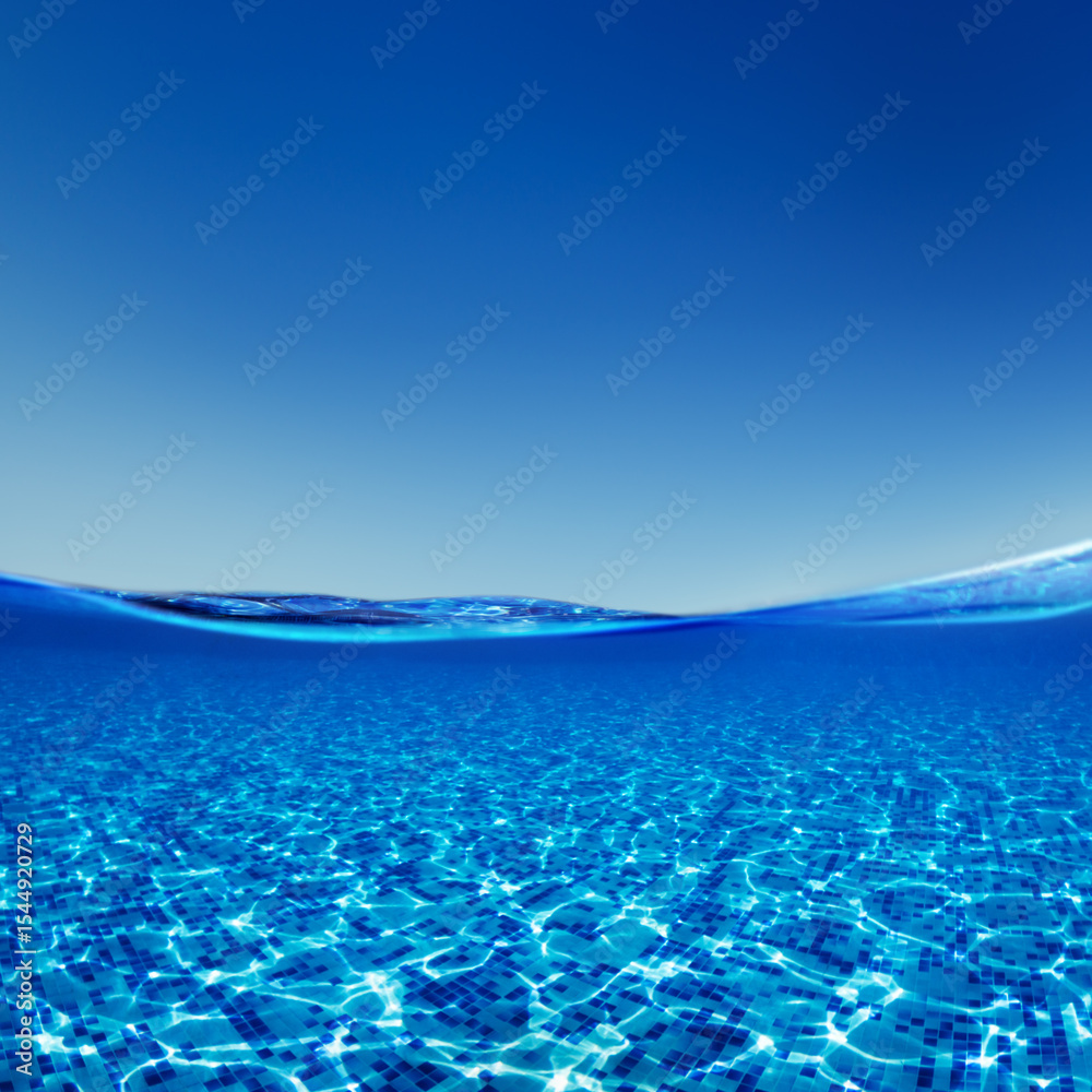 Fototapeta premium Swimming pool view on a border of water and air with a blue sky.