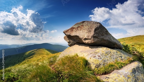 boulder on a hill under blue sky with clouds in summer huge sandstone among the grass journey to beautiful highland of ukraine