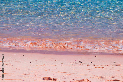 Fototapeta Naklejka Na Ścianę i Meble -  Amazing view of pink beach at Komodo Island, Indonesia. Close-up photo of pink sands with waves and clear water at the beach.