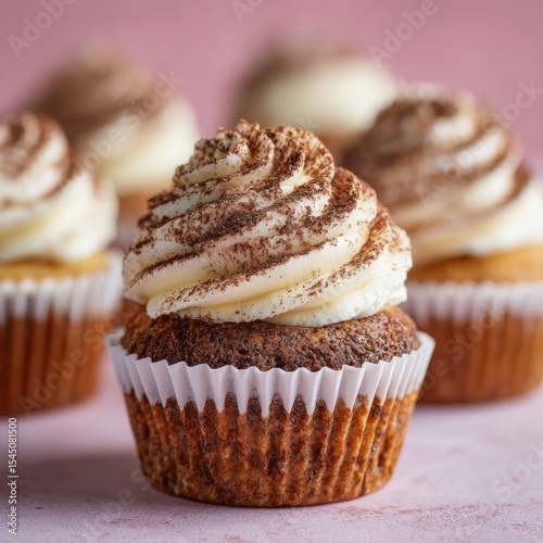 Cupcake with swirled frosting topped with cocoa powder on a pastel background