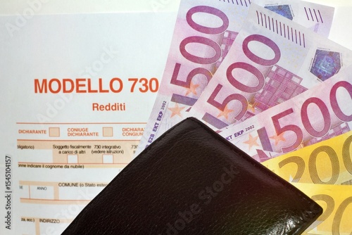 Province of Florence , JUNE 20th 2025, many euro banknotes and leather wallet with the “Modello 730” as background , translating in Italian as declaration of incomes , concept of tax payment . photo