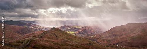 Panorama of shafts of sunlight over Ambleside and Windermere seen on the descent from High Pike, on the Fairfield Horseshoe, Lake District, UK photo