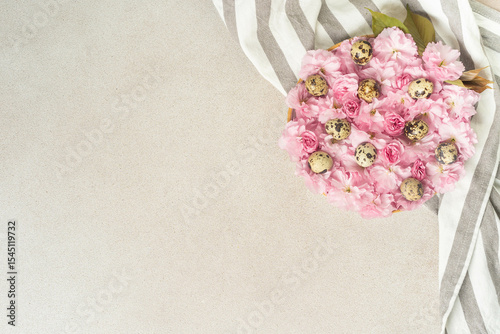 Quail eggs with pink cherry blossoms on striped fabric for elegant decor