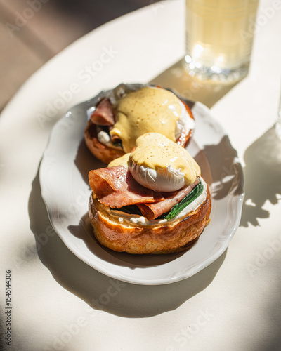 Foto Portion of gourmet benedict eggs with sauce and brioche