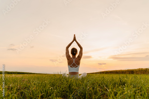 Young woman practicing yoga on nature. Holistic Health and Mental Well-Being.