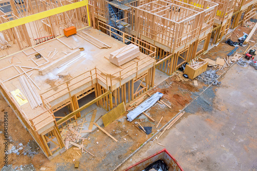 Construction workers are assembling wooden frames at site with materials scattered around on works day.