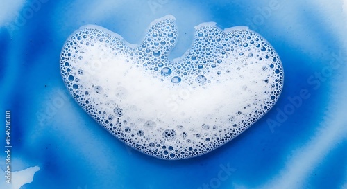 Heart shaped soap suds on blue background